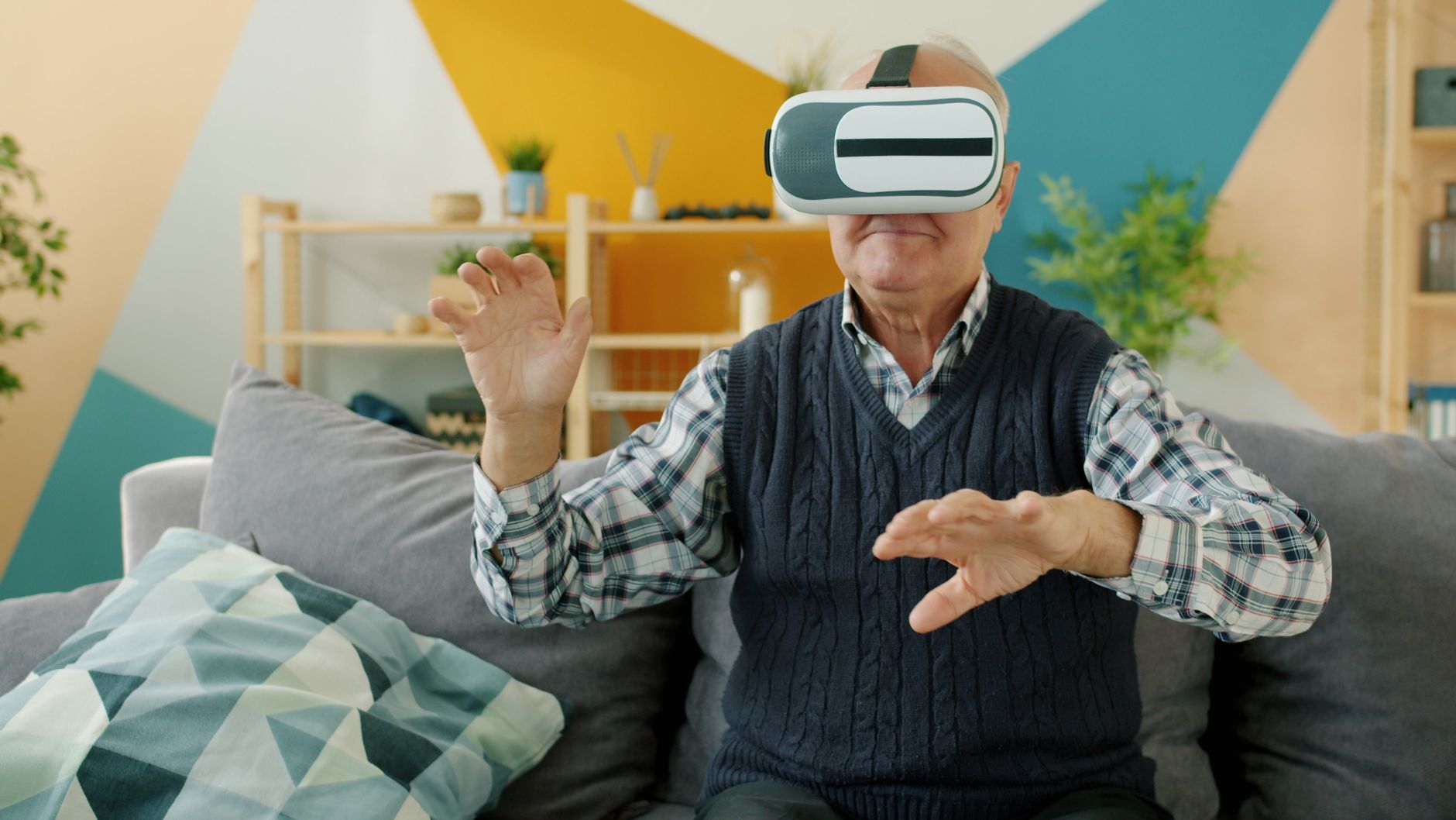 Elderly man using VR glasses at home. Exploring technology.